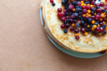 Breakfast Thin pancakes with frozen berries and honey