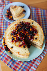 Pancakes with wild berries in  plate.Maslenitsa
