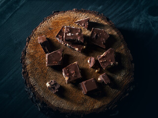 Pieces of milk chocolate with nuts on the table
