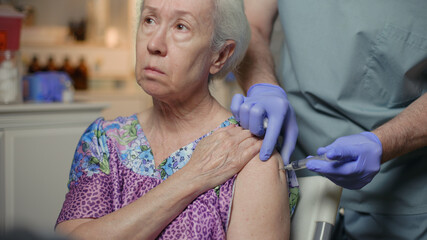 doctor giving an elderly patient covid-19 vaccine