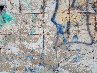 The old concrete wall is painted with paints.