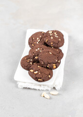 Cocoa cookies with peanuts on a ceramic tray on a light background