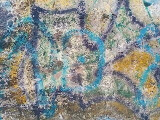 The old concrete wall is painted with paints.