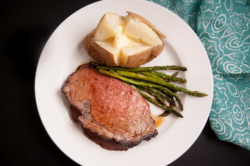prime rib dinner with potato and asparagus