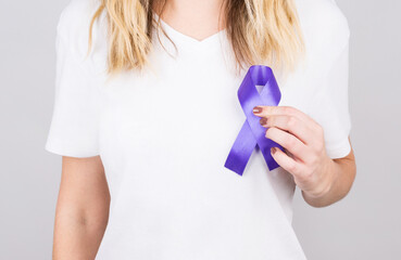 Woman holding purple ribbon on white background. Alzheimer's disease, Pancreatic cancer, Epilepsy...