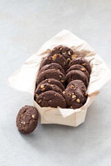 Dessert chocolate cookies with whole peanuts in a box on a light background