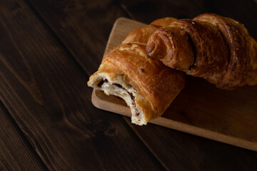 Croissants with chocolate on wooden board