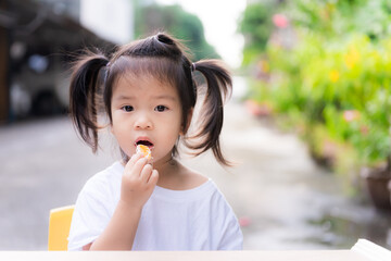 Girl was forced to eat fruit. Cute child eating oranges in front of her house. Parents are forced...