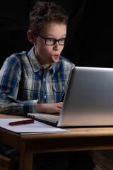 Boy funny on PC with tongue out on laptop