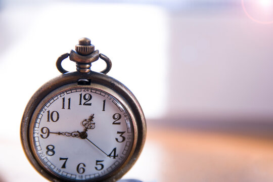Old antique metallic pocket opened watch. time 12:45, noon hour. Watch arrows, passing time, life, deadline