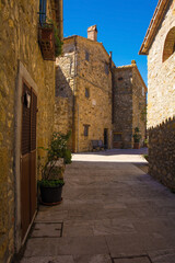 A residential street in the historic medieval village of Poggio Capanne near Manciano in the Grosseto Province of Tuscany, Italy. The 15th century Church of the Visitation of Mary, Chiesa della Visita