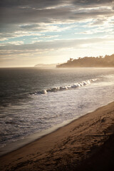 Waves and golden sunset at Big Sur California with sea spray in the air and the ocean