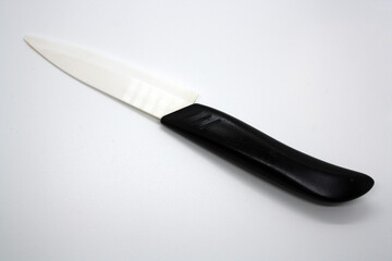 Ceramic knife with white blade and black handle.