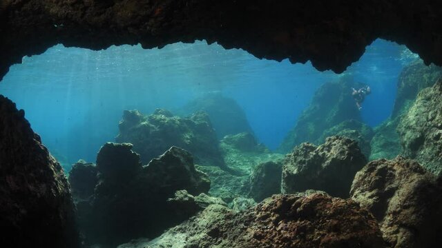 freediver apnea woman free diving in a cave underwater with nice lightning and reflection on water female diver