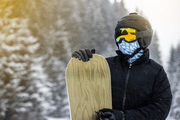 Young girl snowboarder holding her snowboard