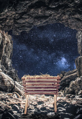 Vertical shot of a manger in a cave under a bright starry sky during the birth of Jesus Christ