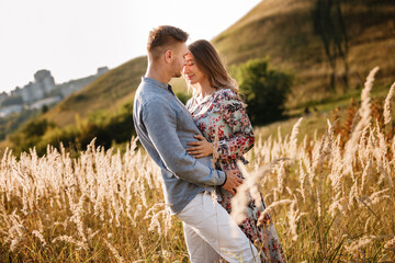 young loving couple hugging outdoors in the field on summer. concept of happiness and love. close up photo. love story