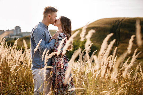 young loving couple hugging outdoors in the field on summer. concept of happiness and love. close up photo. love story