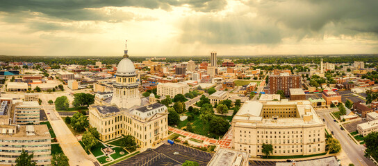 Aerial panorama of the Illinois State Capitol dome and Springfield skyline under a dramatic sunset....