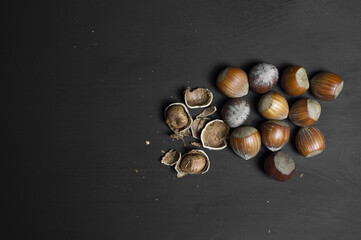 Some shelled hazelnuts on the right with shell fragments around them, isolated on a black background. put your text.