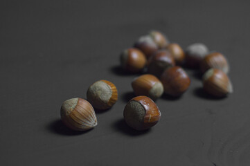 Fresh hazelnuts over black background with soft defocus