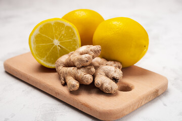 Ginger and lemon on a cutting board as ingredients for lemonade detox