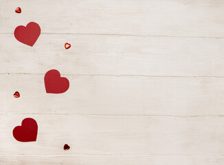 Valentine's Day. Red hearts on a white wooden background. Place for text. Red crystals.