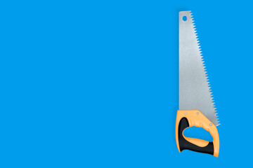 Metal hand saw with a plastic handle on a blue background.