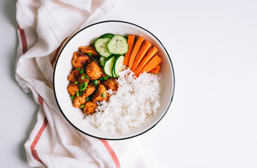Healthy bowl with Chicken meat, rice and vegetables in a white plate on the table.