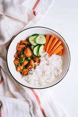 Healthy bowl with Chicken meat, rice and vegetables in a white plate on the table.