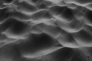 sand dunes close-up view from above. Background black and white photo. sand waves. texture of sand on the beach.