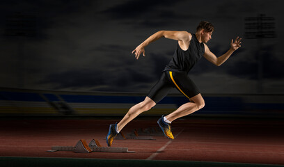 Professional sprinter training at the stadium in the evening