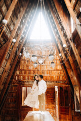Young couple is standing on the table inside cozy wooden building