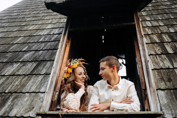 Obraz premium Young couple standing near the window in a wooden house in the middle of the lake.