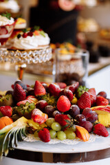 Beautifully decorated catering banquet table with different fresh fruits and sweet on corporate birthday party event or wedding celebration
