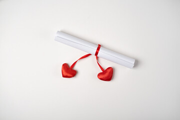 Valentine Day love letter tied with red ribbon with red hearts on light background. Valentine's day concept.Greeting background for Valentine's Day. Flat lay.