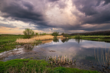 The smooth surface of the river and the gloomy sky