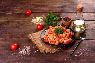Delicious fresh paste with tomato sauce with spices and herbs on a dark background