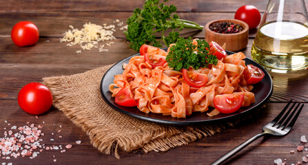 Delicious fresh paste with tomato sauce with spices and herbs on a dark background
