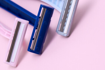 Disposable plastic razor blades for everyday morning routine and shaving unwanted hair on face, legs and armpits, grooming concept on pink background