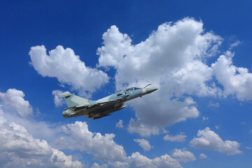 Ultra zoom photo of fighter interceptor plane performing extreme stunts in deep blue cloudy sky
