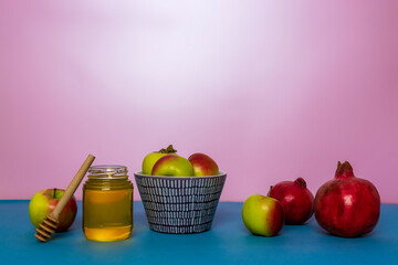 Jar of honey, apples and pomegranates on the table for the holiday of Rosh Hashanah