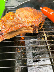 preparing a tomahawk with longaniza red chiles onion and tomatoes on a grill