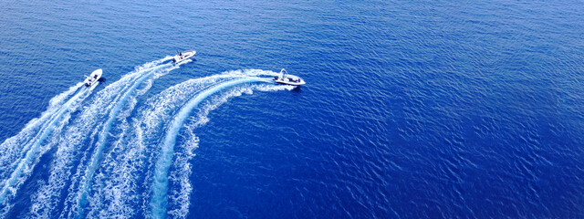 Aerial drone ultra wide top down photo of synchronised powerboats cruising in high speed in deep blue open ocean sea - obrazy, fototapety, plakaty