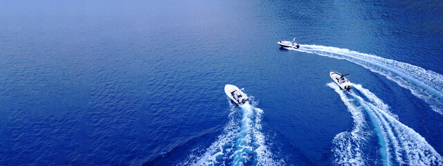 Aerial drone ultra wide top down photo of synchronised powerboats cruising in high speed in deep blue open ocean sea - obrazy, fototapety, plakaty