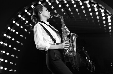 Gorgeous brunette model woman in fashionable formal suit with saxophone