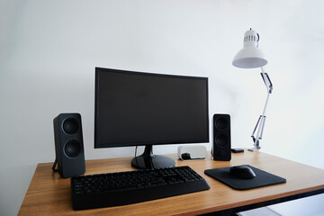 Mesa de trabajo para plataformas digitales con computadora, parlantes de audio, mouse y teclado