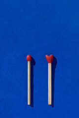 Two heart shaped red matchsticks couple, blue background. Сoncept of perfect match, fire of love and passion. The one and only. Happy Valentines Day. Holiday romantic wedding poster, greeting card.