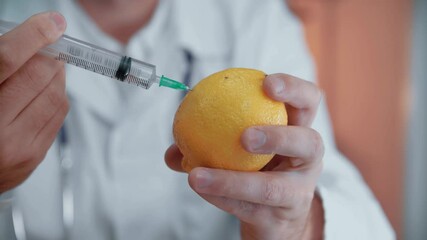 Injection into lemon - fruit and syringe chemical GMO food. Close-up. - Powered by Adobe