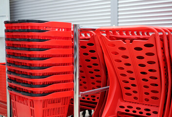 Red plastic shopping carts and baskets in the supermarket. Shopping concept.